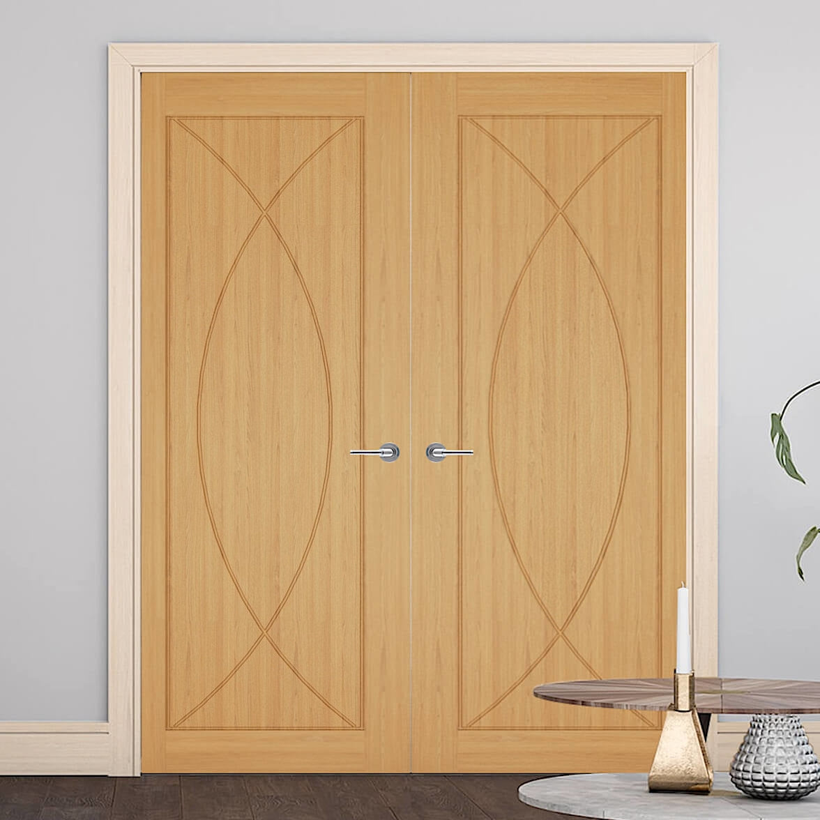 Amalfi Oak Door Pair - Solid panel Amalfi door with symmetry cut curves, the pair has an offset architrave and skirting, the walls are a shade of blue and we have a coffee table to the bottom left of the image.