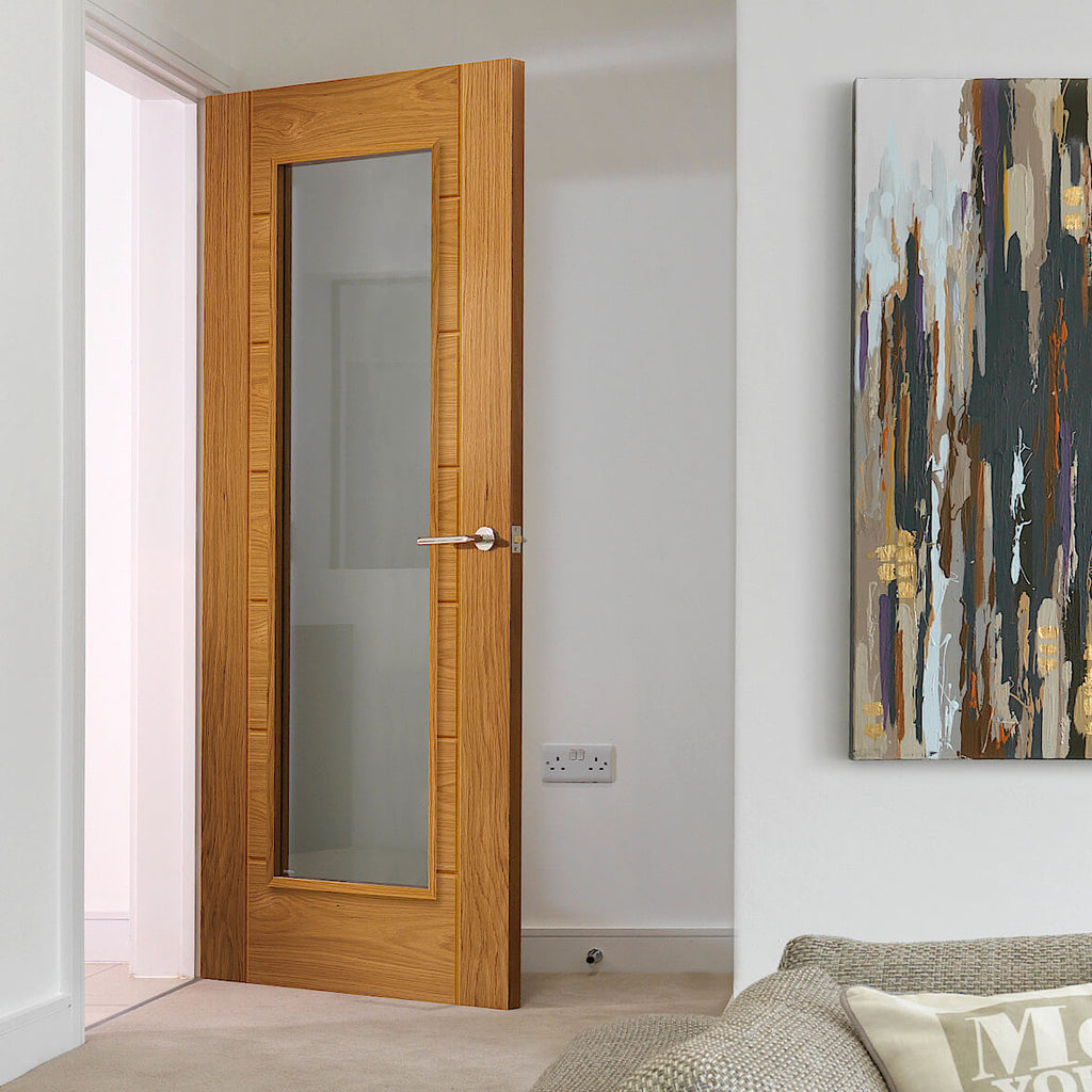 Oak Palomino Clear Glazed Internal Door - This design of door has a large panel of glass in the centre , the wall and floor are all in a neutral colour with a large multi coloured painting to the right of the image