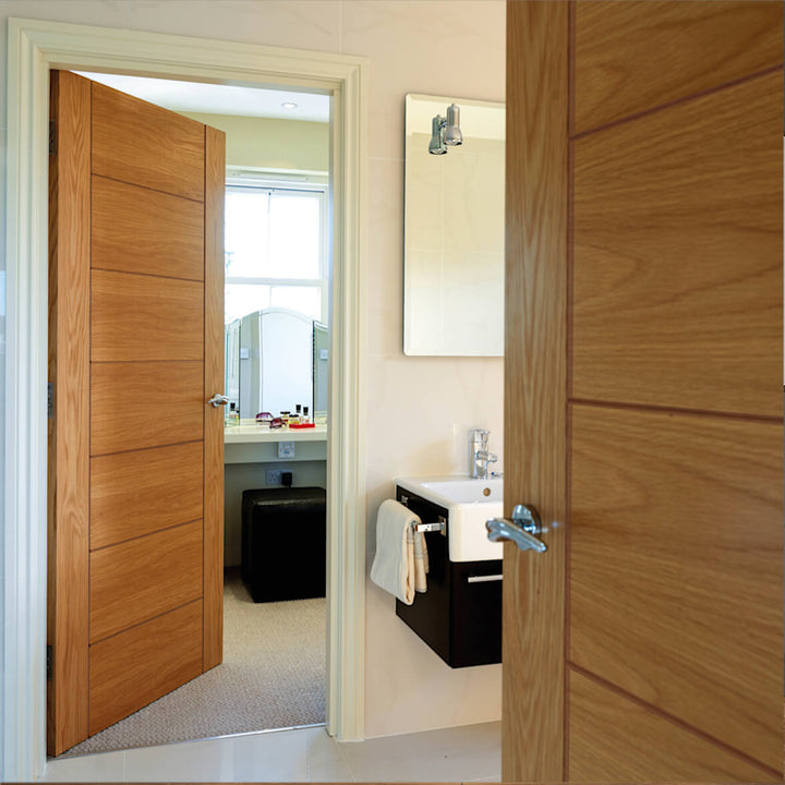 Oak Palomino Internal Door - The door design has horizontal and vertical grooves which create a 7 panel design, the outer stiles of the rails are plain without any grooves, two doors are open on the images both leading towards an ensuit